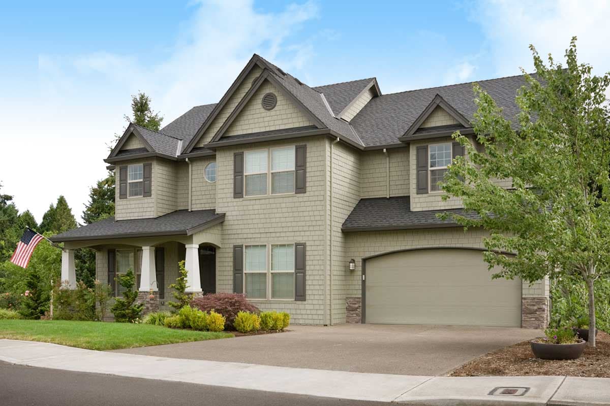 House plan exterior: Two-story home with a covered front porch, gables, dormers, and an attached garage.