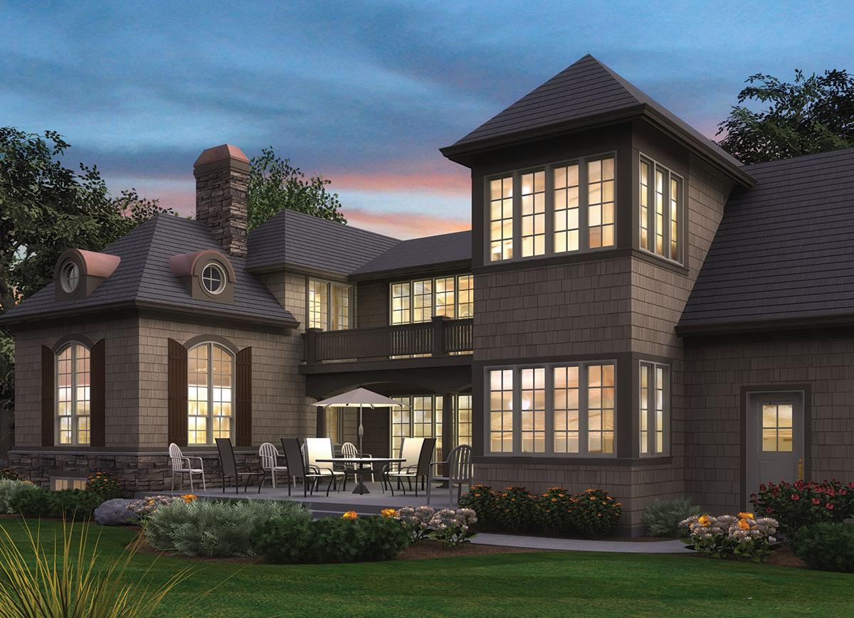 House plan exterior with multi-story structure, dormers, stone chimney, covered balcony, and large windows.