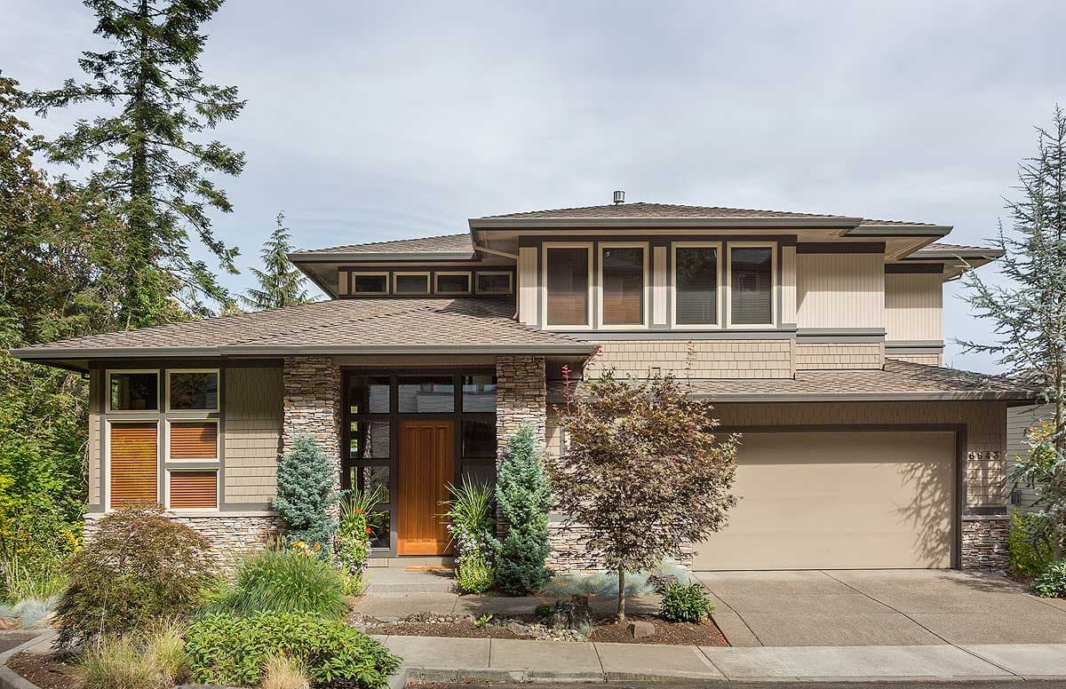 Modern house plan exterior with stone accents, multi-level rooflines, wide eaves, and integrated garage.