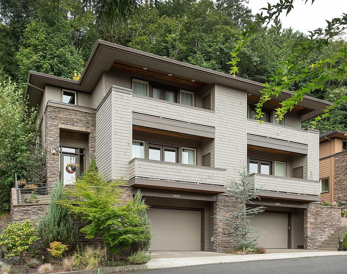 Modern house plan exterior with layered stone, shake siding, stacked garages, and multiple balconies.