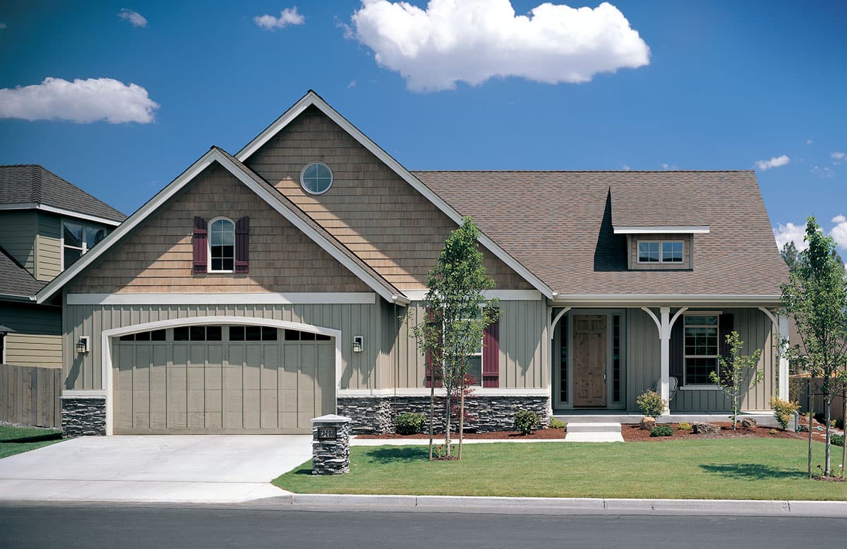 House plan exterior features a multi-story design with shingle and board siding, gabled roof, dormer, and covered porch with arched supports.