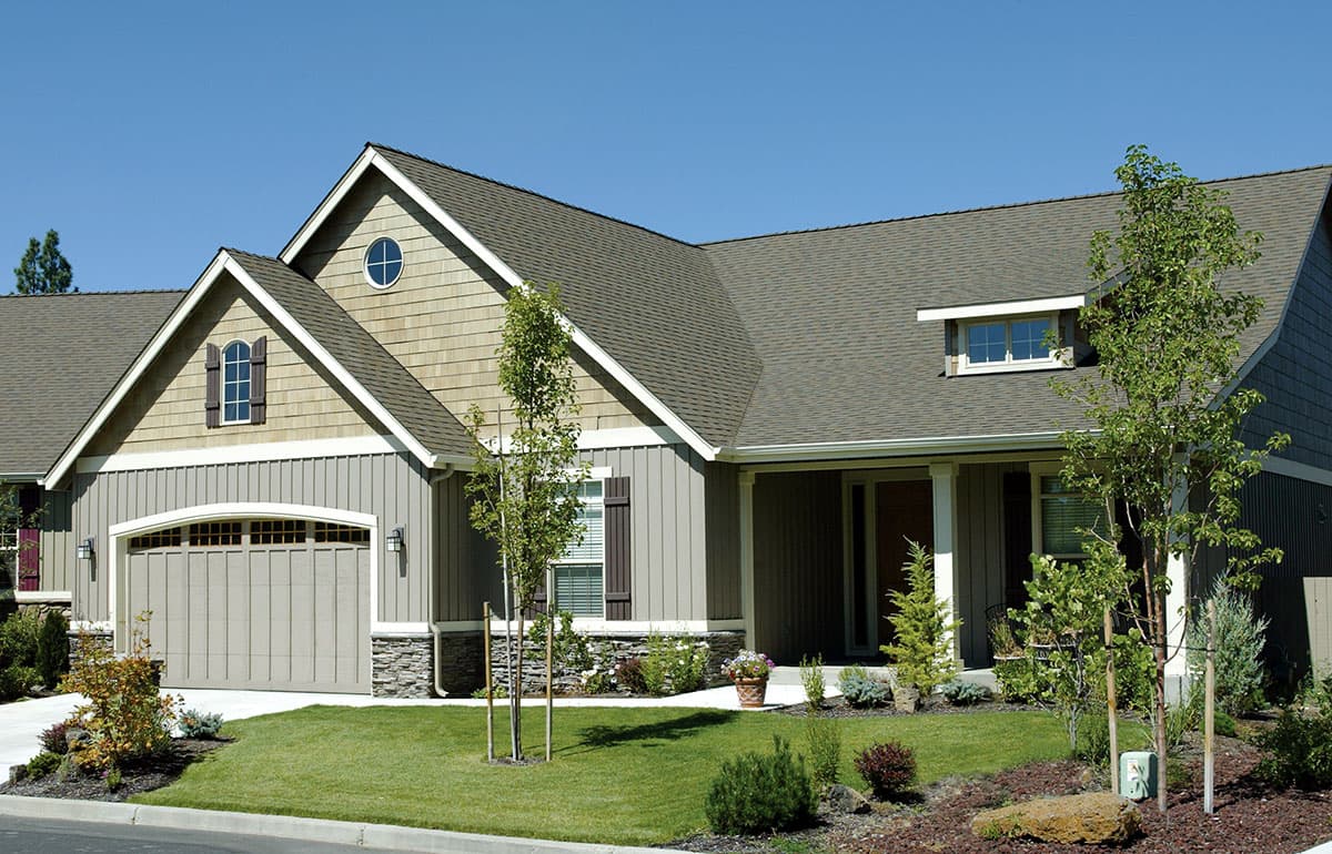 House plan exterior: Ranch style with prominent gables, a covered porch, shaker siding, and a wide garage.