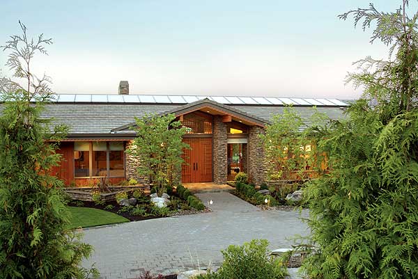 House plan exterior: a low-slung, single-story home with a wide, wood-paneled entry, stone accents, and a long horizontal skylight.