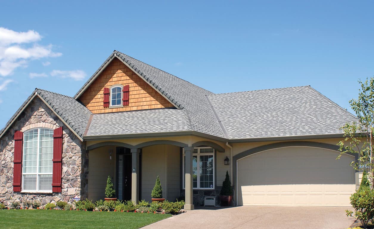 House plan exterior with stone accents, a covered porch, gable dormer, and attached garage.
