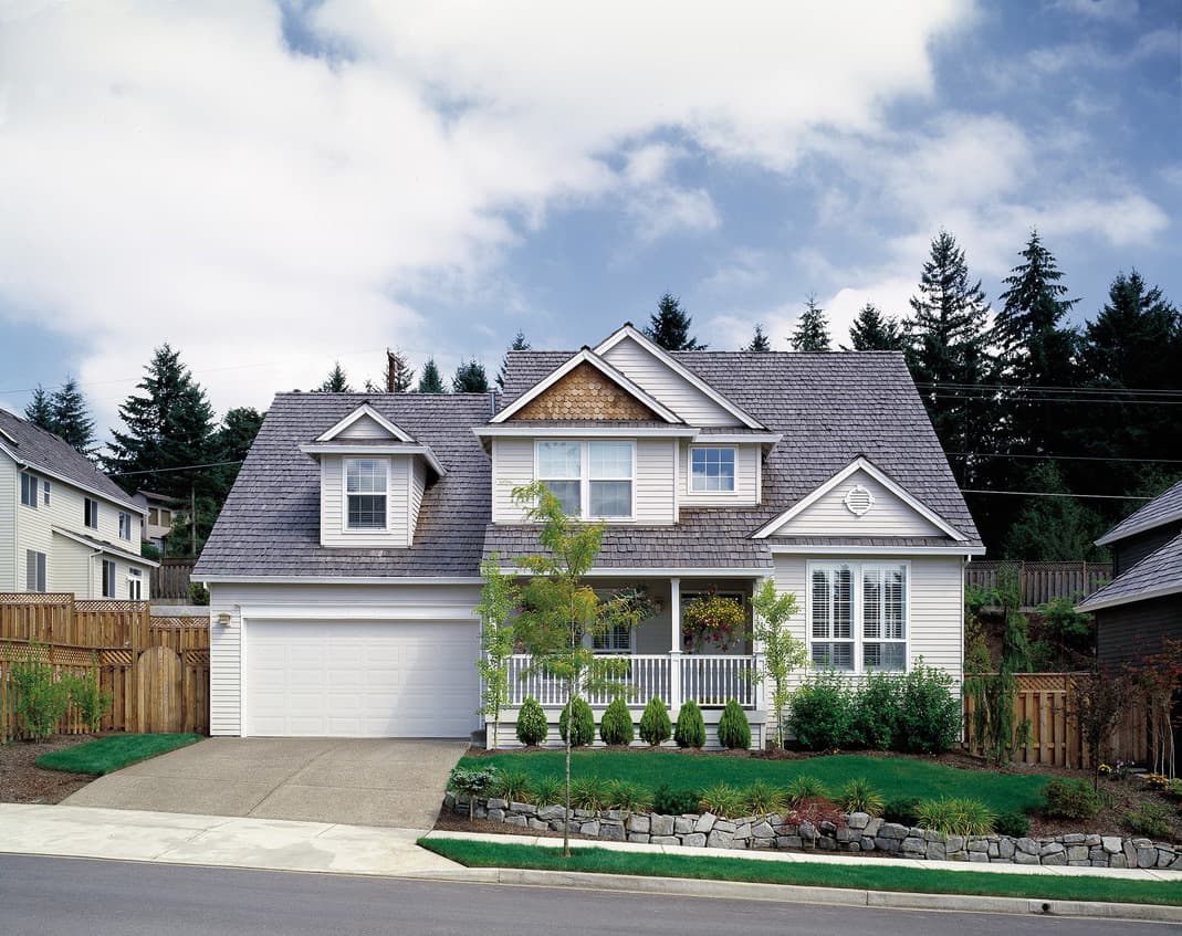 Two-story house plan exterior with dormers, a covered front porch, and a prominent gable.