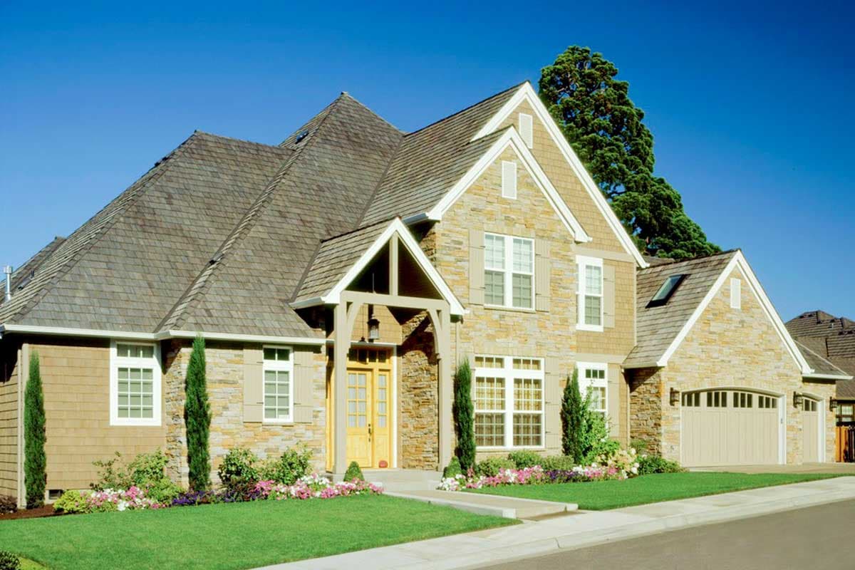 House plan exterior: Two-story home with stone and shingle siding, prominent gables, and a covered entryway with arched supports.