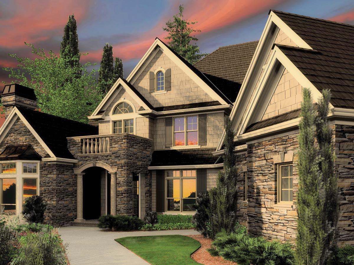 House plan exterior featuring stone facade, arched entryway, balcony, multiple gables, and shingle siding.