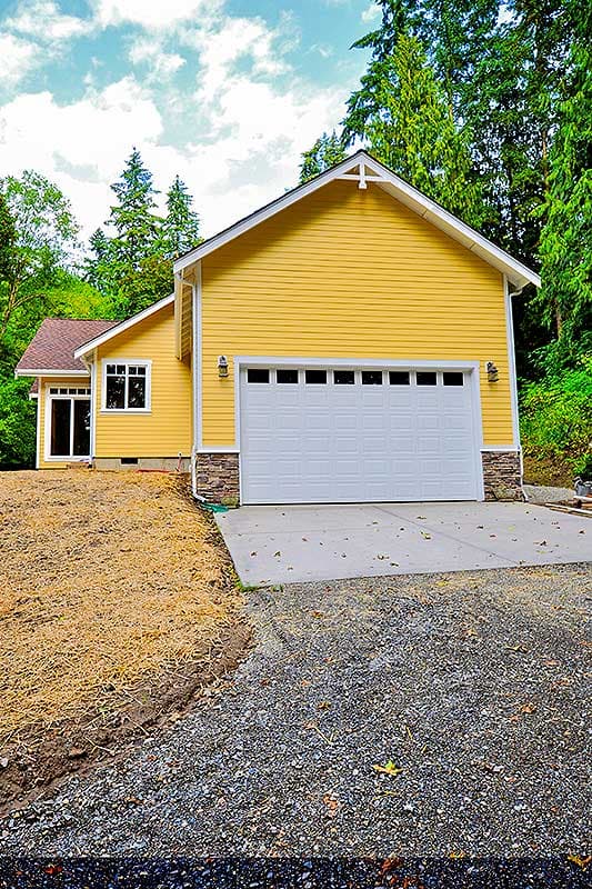 House plan exterior of a yellow, one-story home with a white garage door, stone accents, and a gable roof.