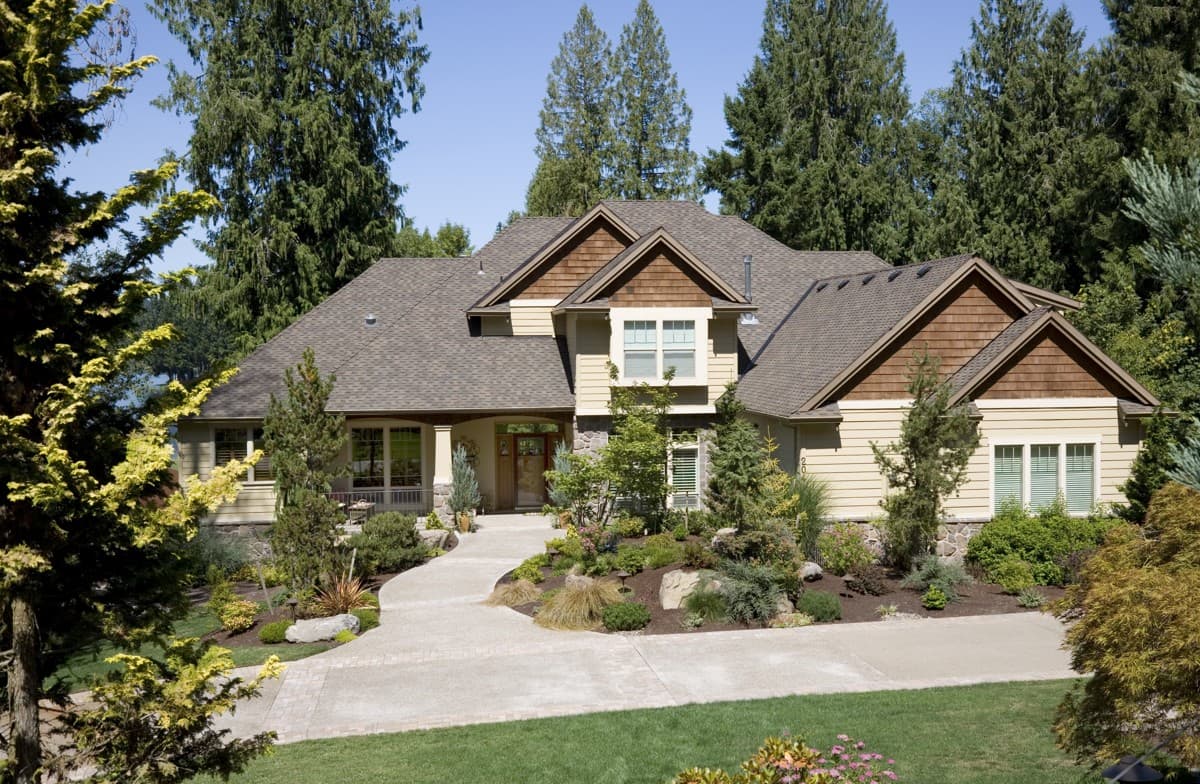House plan exterior: Craftsman style, two stories, covered porch, prominent gables with cedar shakes, and bay window.