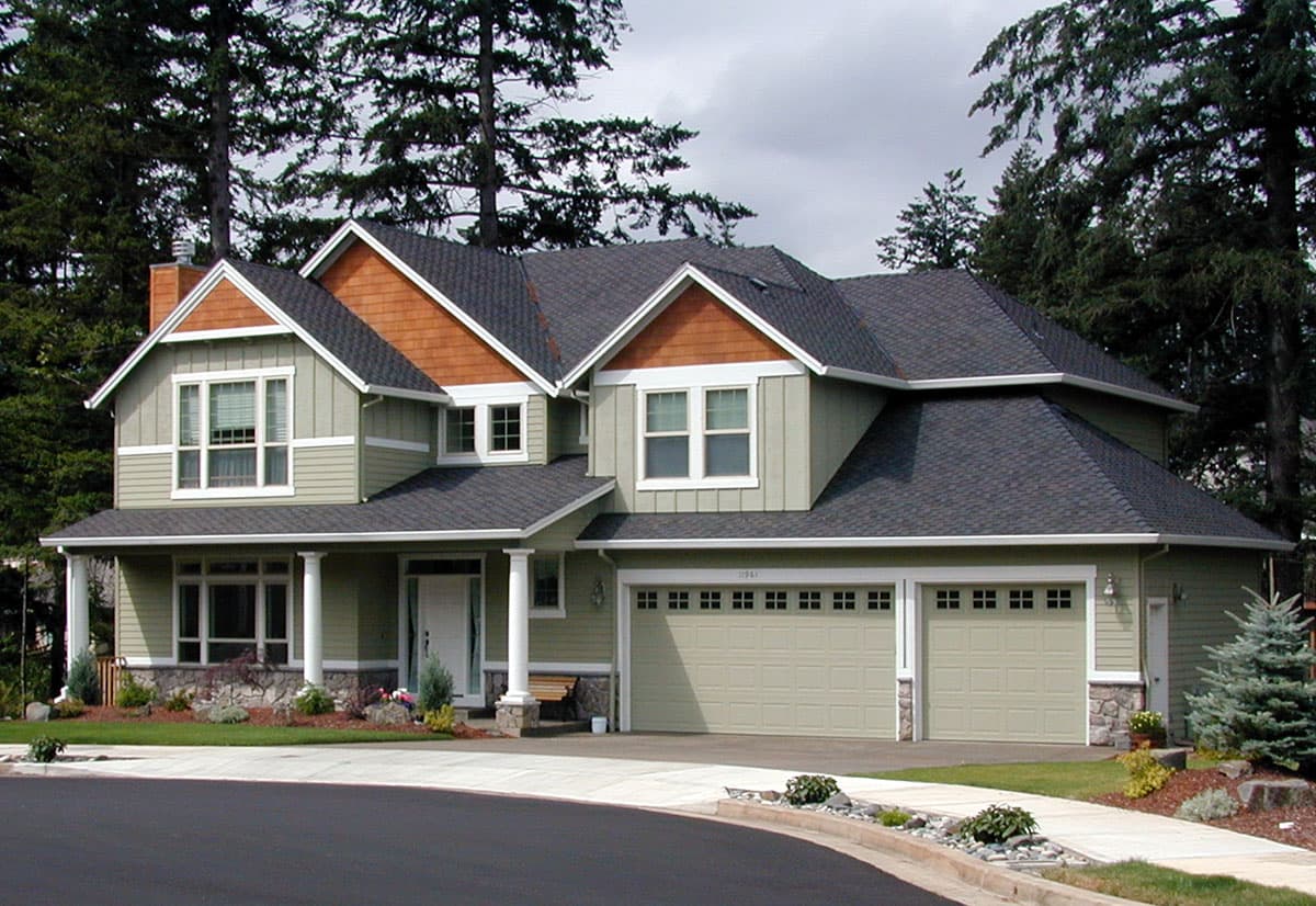 House plan exterior: Two-story Craftsman style home with a wrap-around porch, gables, and a three-car garage.