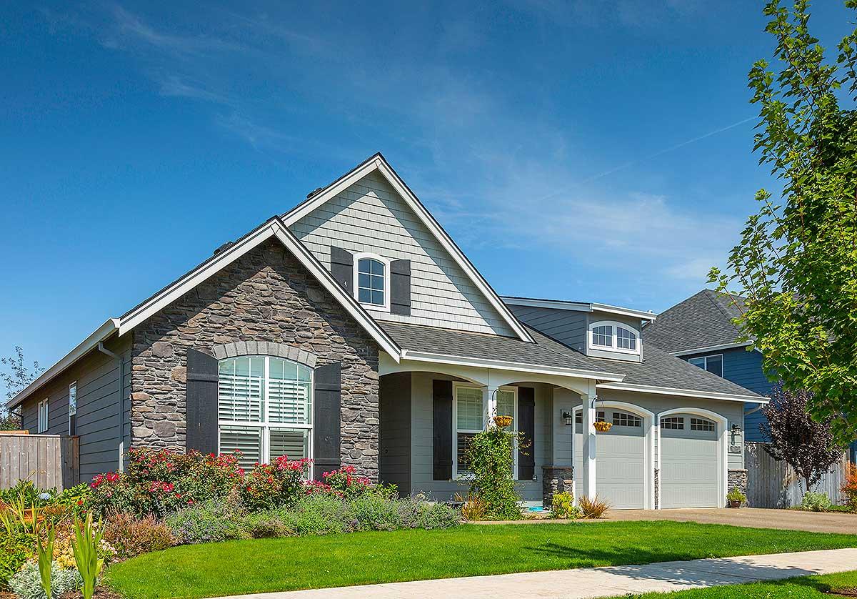 Modern farmhouse house plan exterior with stone facade, gable roof, dormer window, and attached two-car garage.