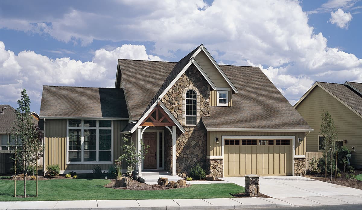 House plan exterior: Two-story home with gable roof, stone accents, arched window, and attached garage.