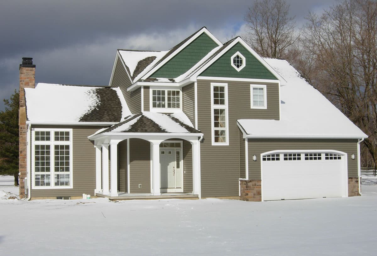 House plan exterior: Two-story home with covered entry porch, prominent gables, stone accents, and attached garage.