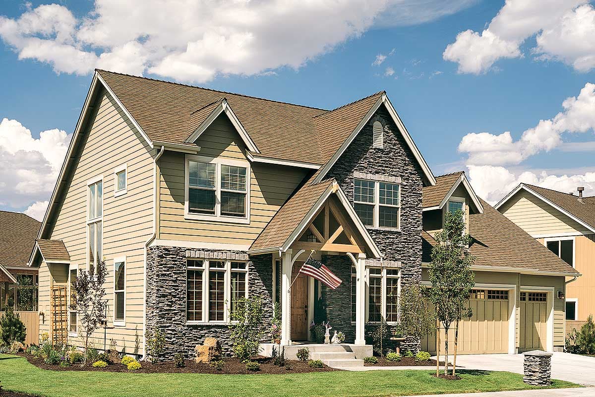 House plan exterior: Two-story home with partial stone siding, prominent gables, and a covered entry with exposed timber framing.