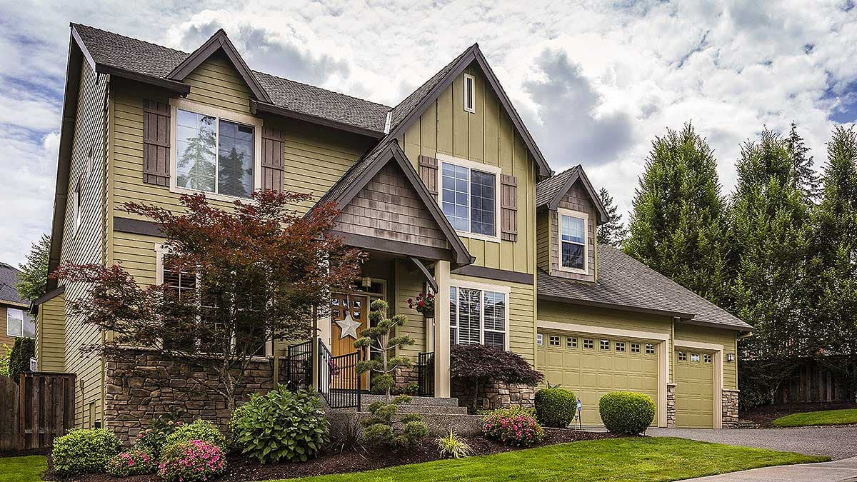 Two-story Modern Farmhouse exterior with a covered porch, multiple gables, stone accents, and a three-car garage.