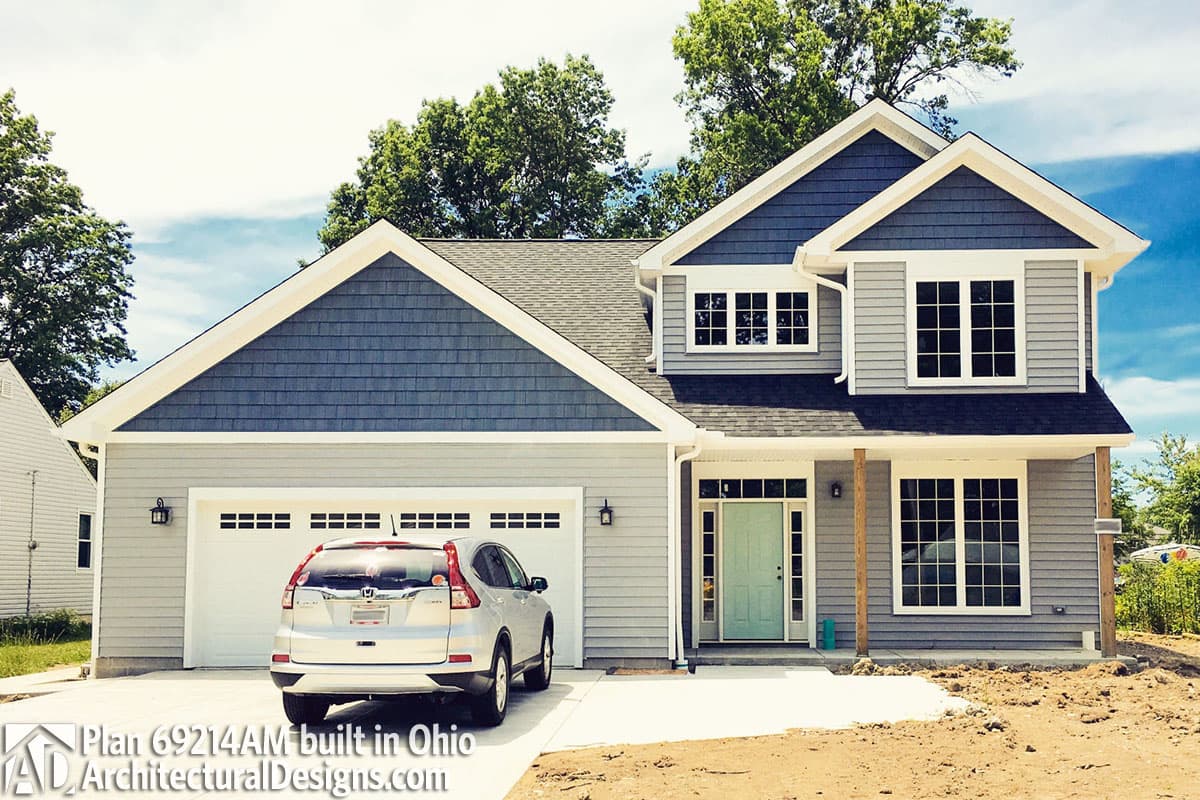 House plan exterior with gabled dormers, two-car garage, covered entry, and gray lap siding.