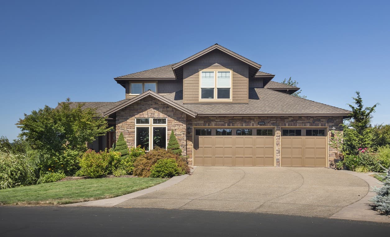Craftsman style house plan exterior, two stories, stone facade, prominent gable, and a three-car garage.