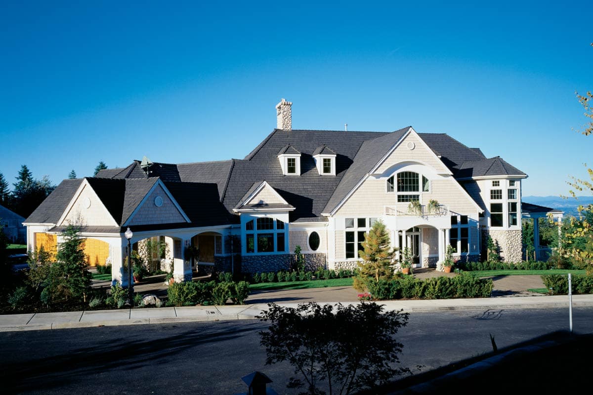 House plan exterior: Craftsman style, two stories, large arched window, covered entryway, and stone accents.