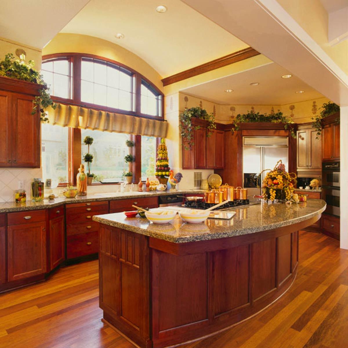 Kitchen with cherry cabinets, granite island, and arched window.