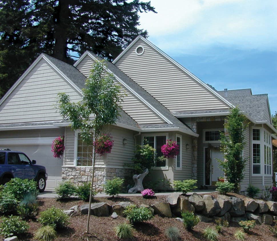 House plan exterior with stone base, gabled rooflines, and attached garage. Features siding and multiple windows.