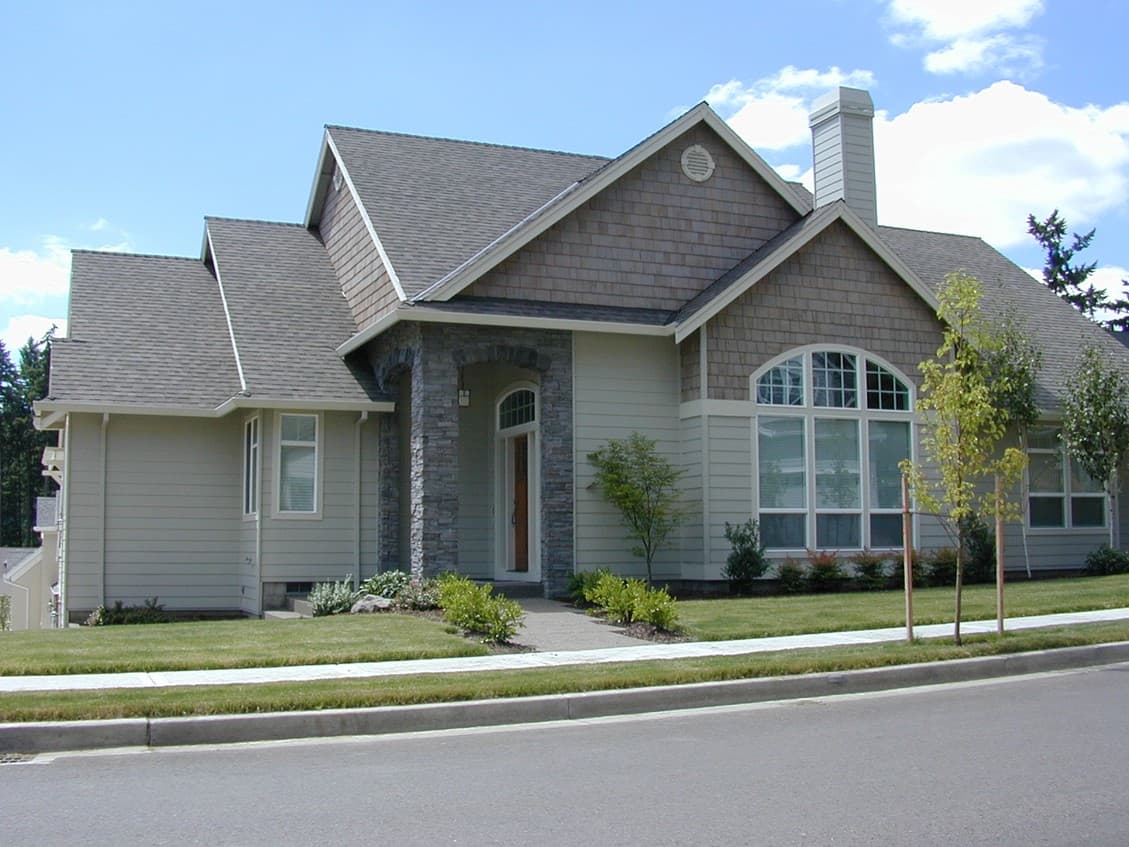 House plan exterior: Ranch style, covered entry with stone pillars, arched window, and gabled dormer.