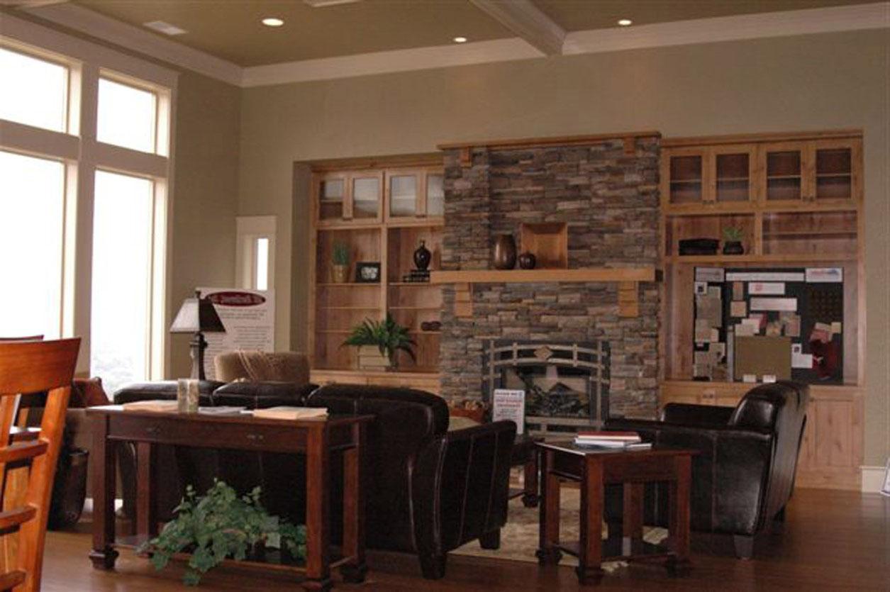 Living room with stone fireplace, built-in bookshelves, and large windows.