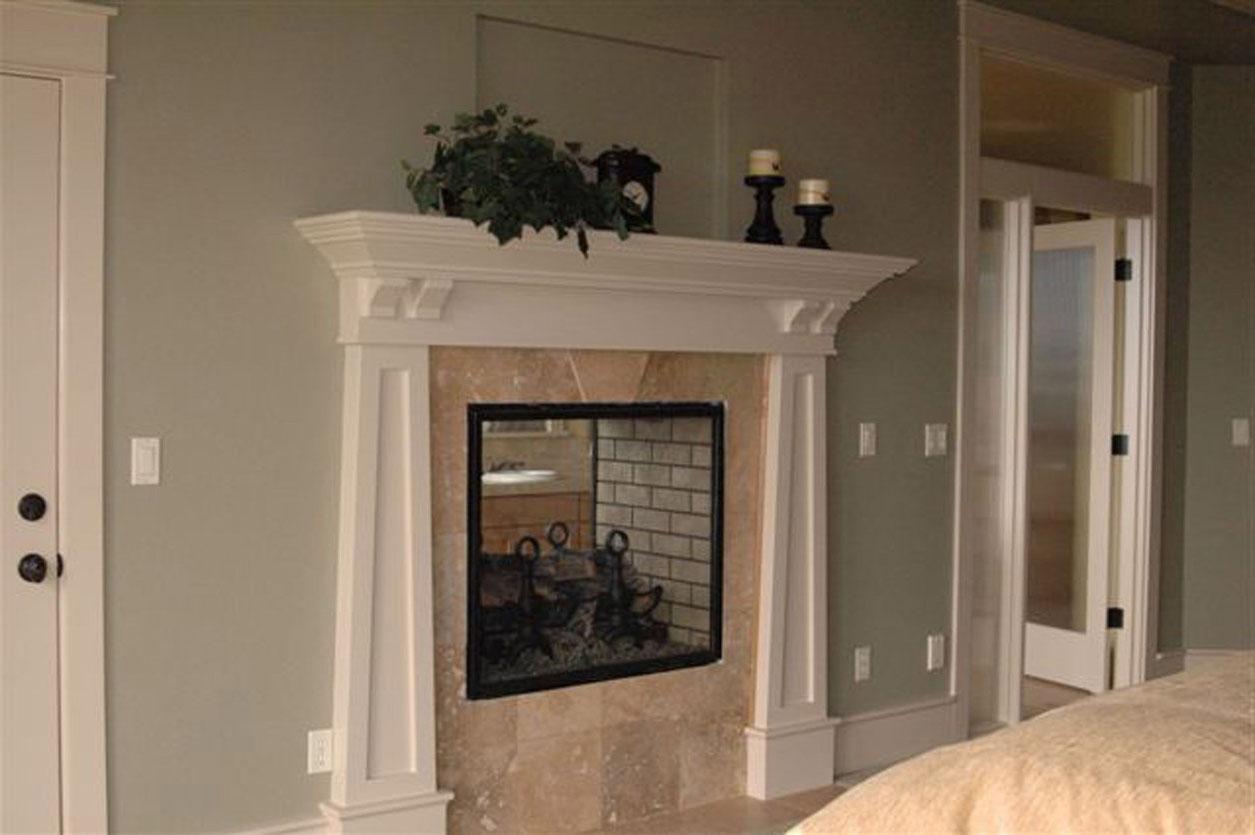 Interior view: Fireplace with marble surround, white mantel, and brick hearth. Double doors visible.