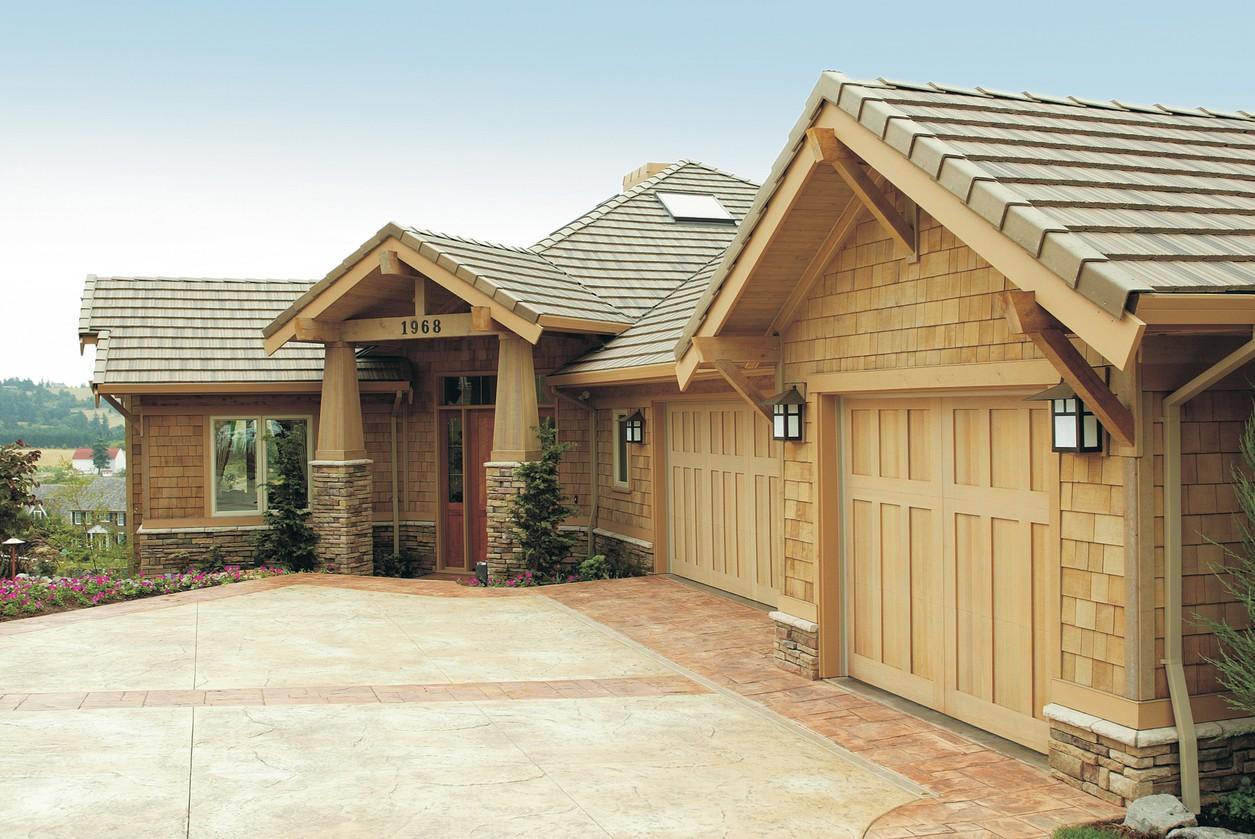 Craftsman style house plan exterior with shake siding, stone accents, covered entry with timber posts, and a triple garage.