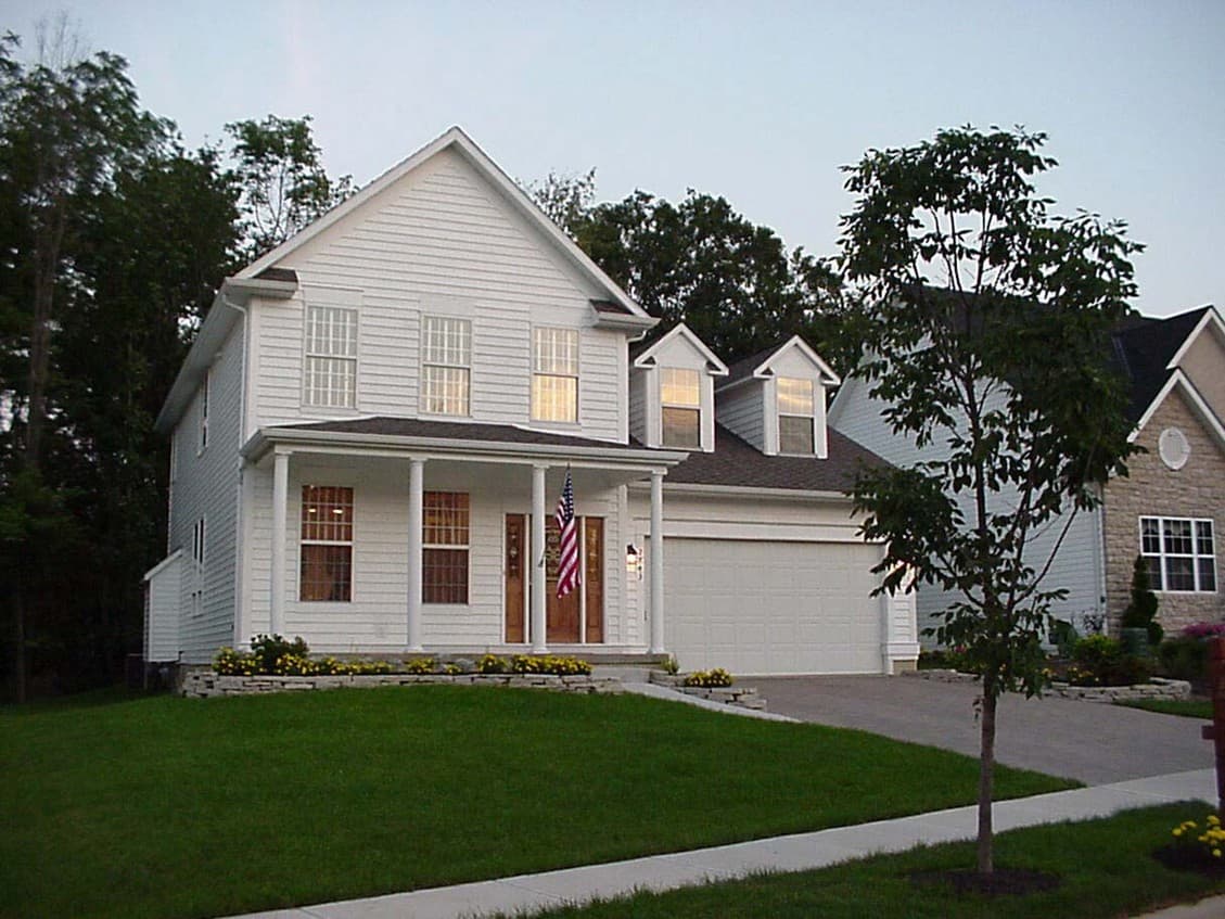 House plan exterior: Two-story white siding home with gabled dormers, front porch with columns, and attached garage.