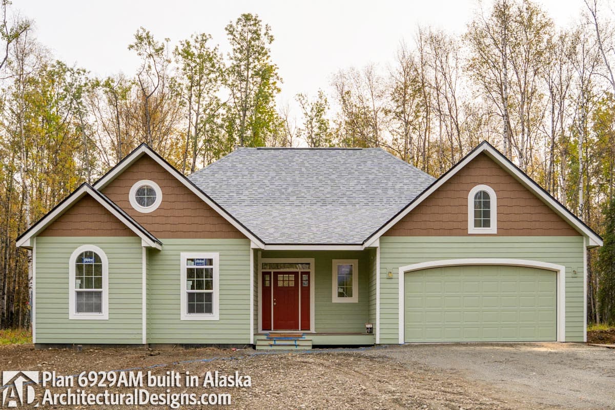 House plan exterior: Single-story home with a prominent gable, arched entry, single dormer window, and side-facing garage.
