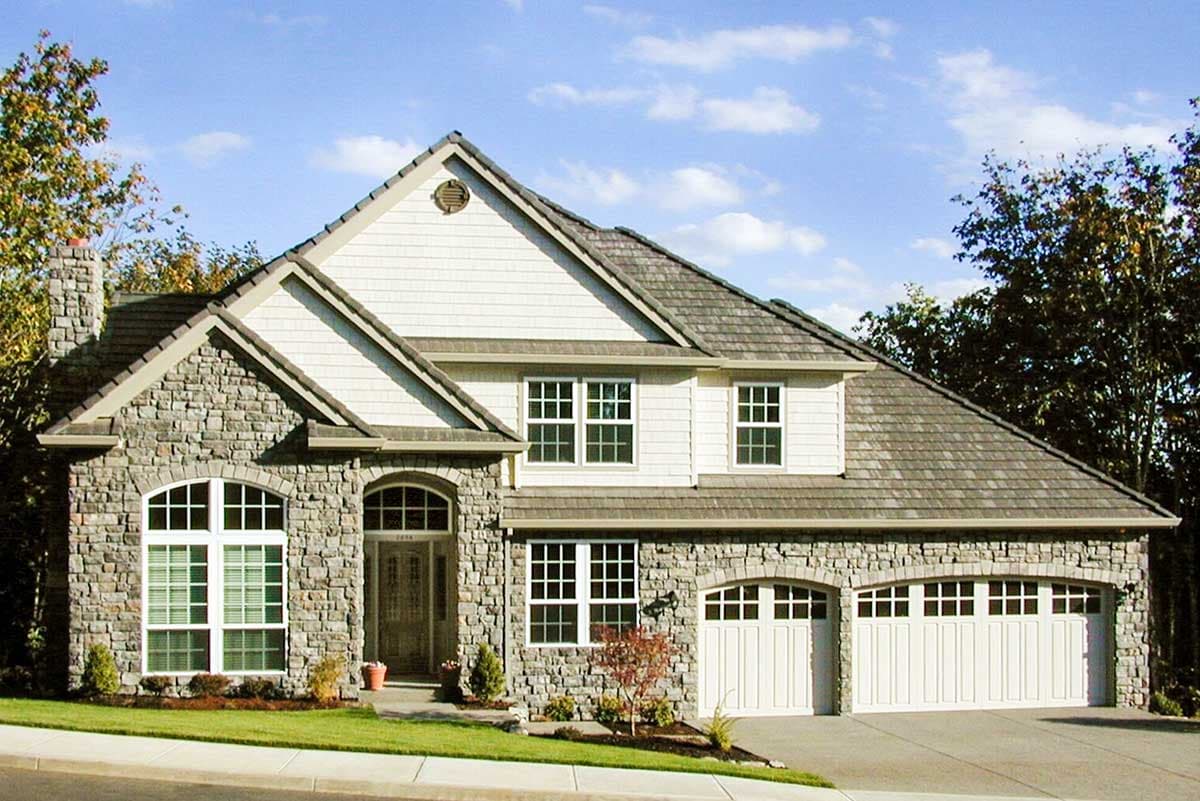 Two-story house plan exterior with stone and shingle facade, arched entryway, multiple gables, and a three-car garage.