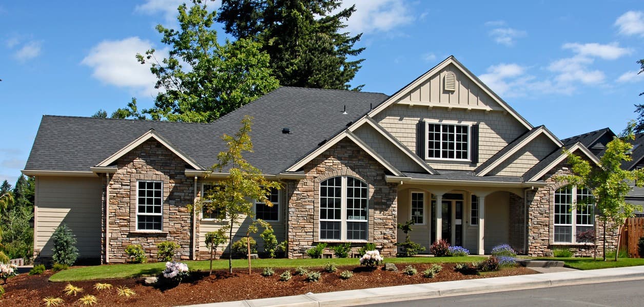 House plan exterior: Single-story with stone accents, multiple gables, arched windows, and covered entry.