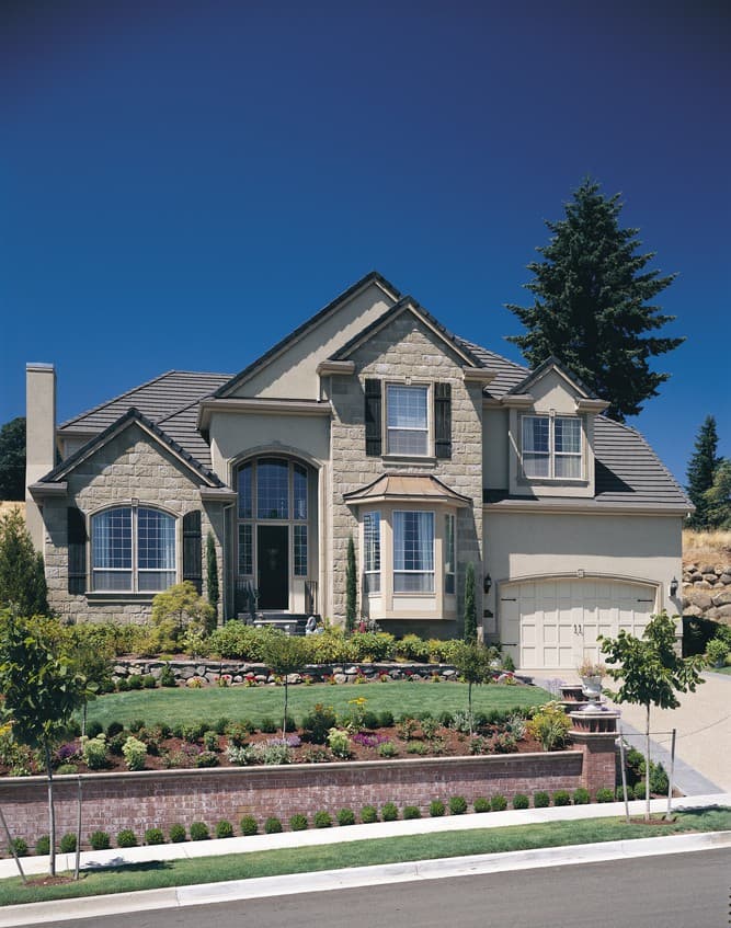 Two-story house plan exterior with stone facade, arched entryway, bay window, and attached two-car garage.