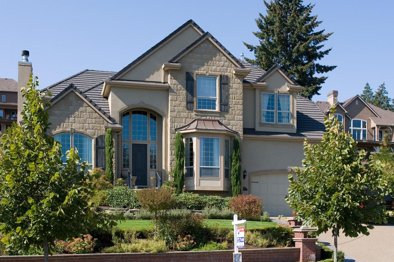 House plan exterior: Two-story home with arched entry, bay window, stone accents, and attached garage.
