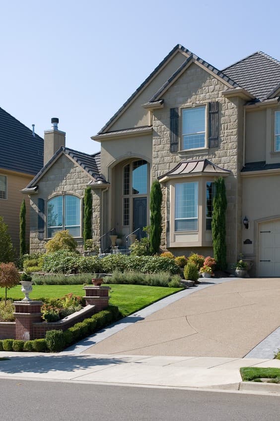 Two-story house plan exterior with stone accents, arched entry, bay window, and attached garage.