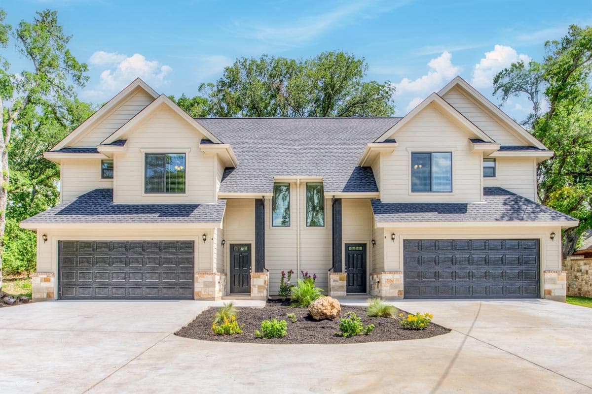 Two-story house plan exterior with side-by-side garages, symmetrical gables, and dark gray doors.