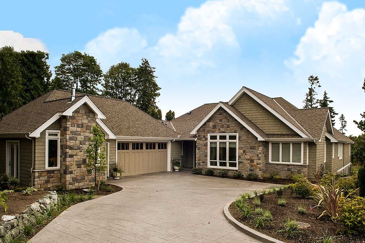 House plan exterior. Ranch style with stone accents. Features include multiple gables, a side-entry garage, and a shake roof.