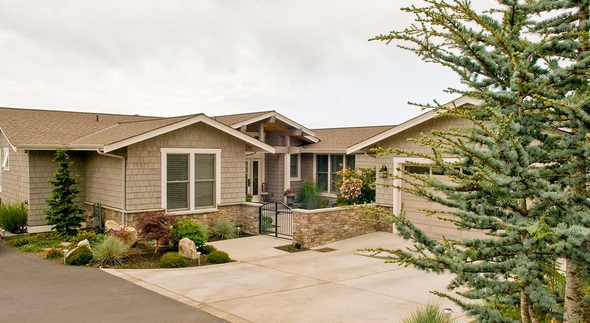 Craftsman style house plan exterior with shingle siding, stone accents, gabled rooflines, and a two-car garage.