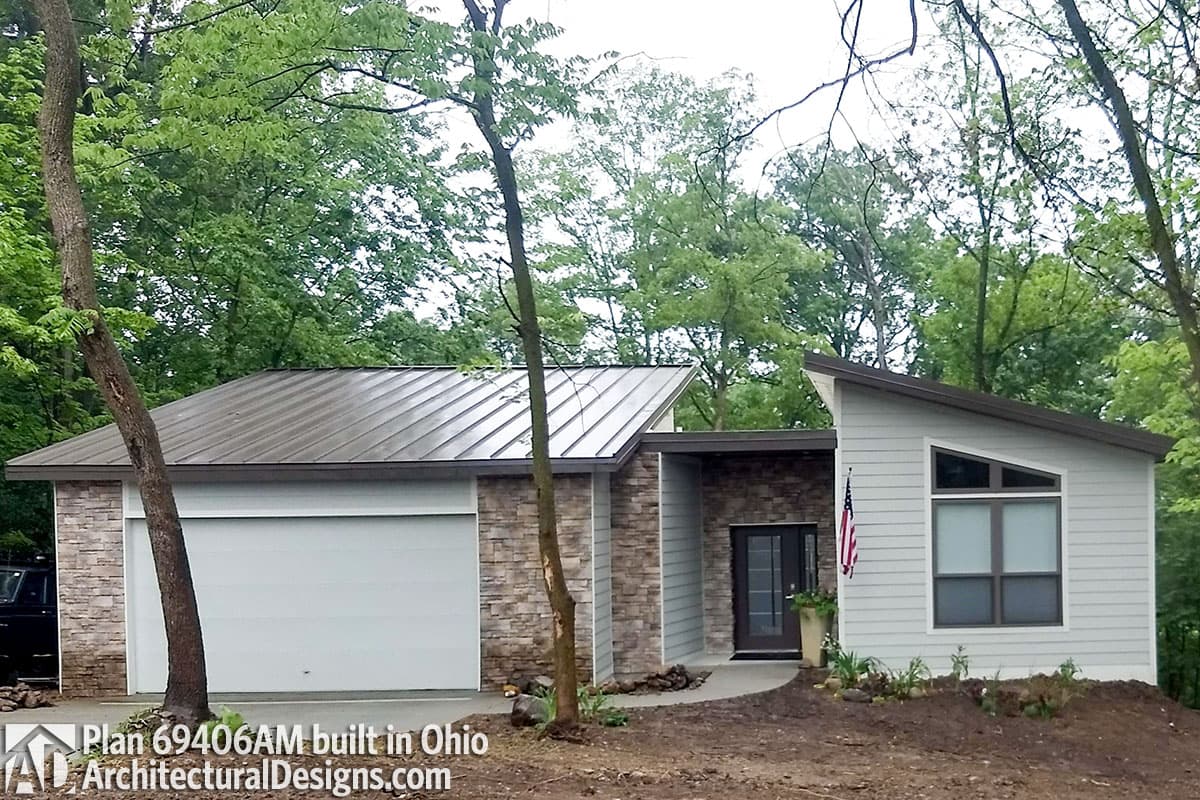 House plan exterior with asymmetrical rooflines, stone accents, a single-car garage door, and a modern entryway.