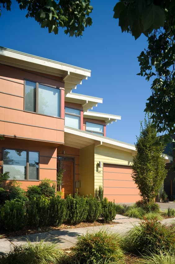 Modern house plan exterior with cantilevered rooflines, horizontal siding, multiple windows, and attached garage.