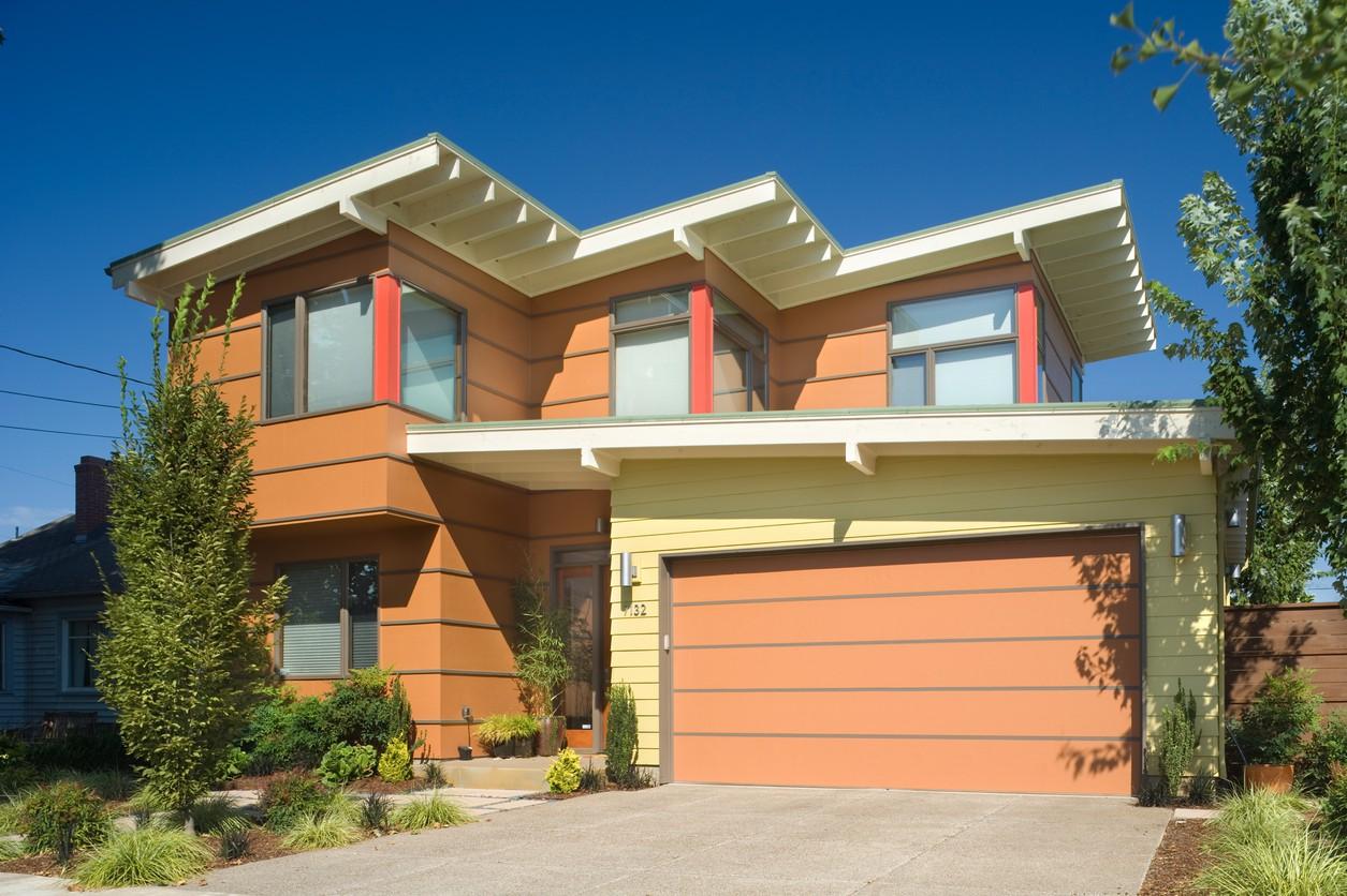 Modern house plan exterior with a two-story design, prominent gables, horizontal siding, and an attached garage.