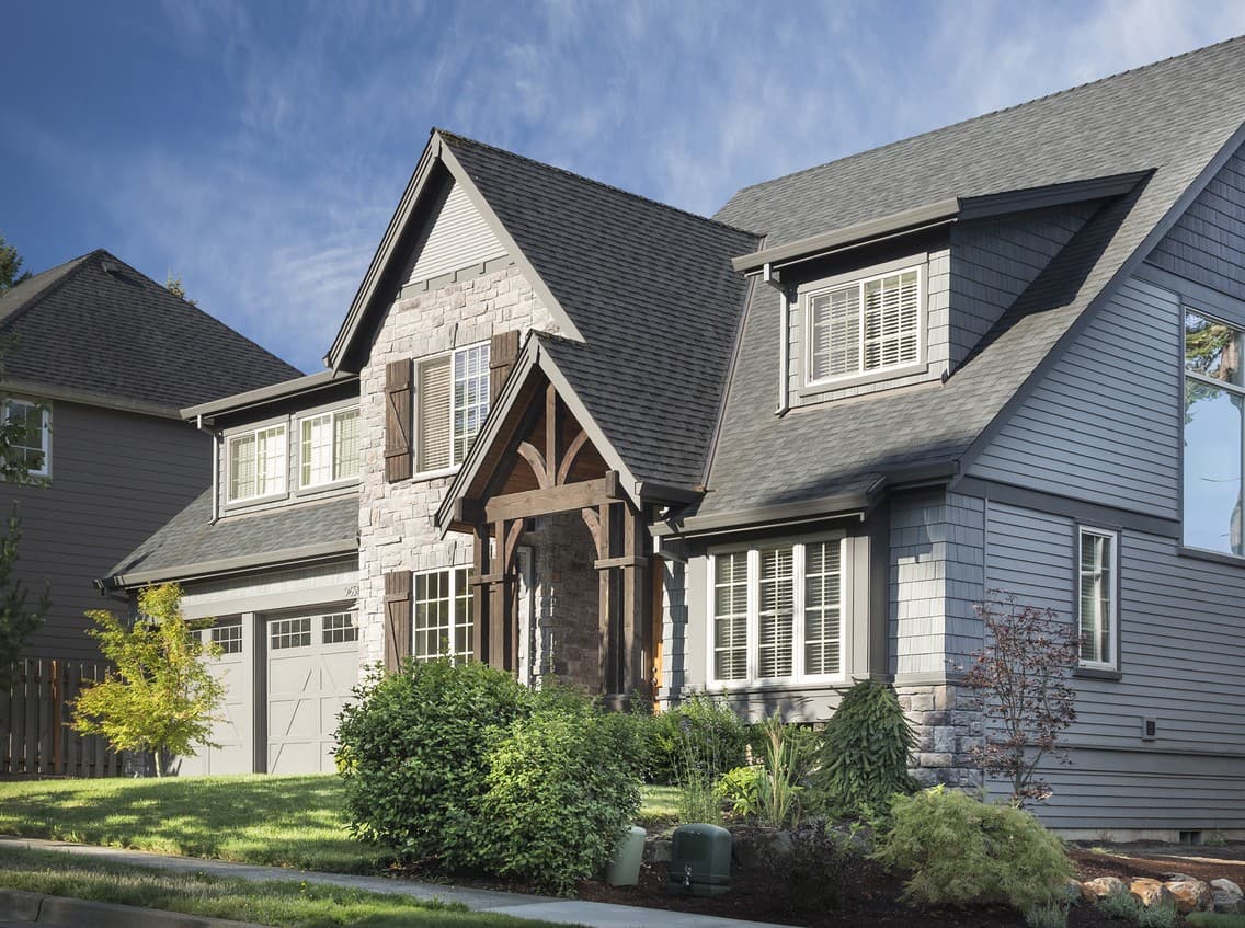 House plan exterior, two stories, stone facade, wood-trimmed gable entry, and a side-facing garage.