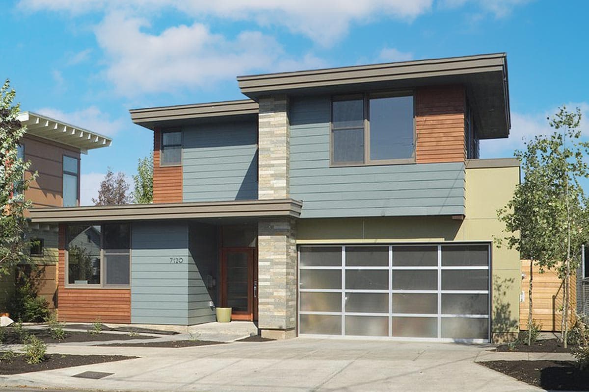 Modern two-story house plan with layered rooflines, horizontal siding, wood accents, stone column, and frosted glass garage door.