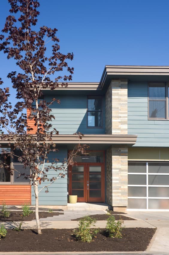 Modern two-story house plan exterior with stacked stone accents, glass garage door, and double glass front doors.