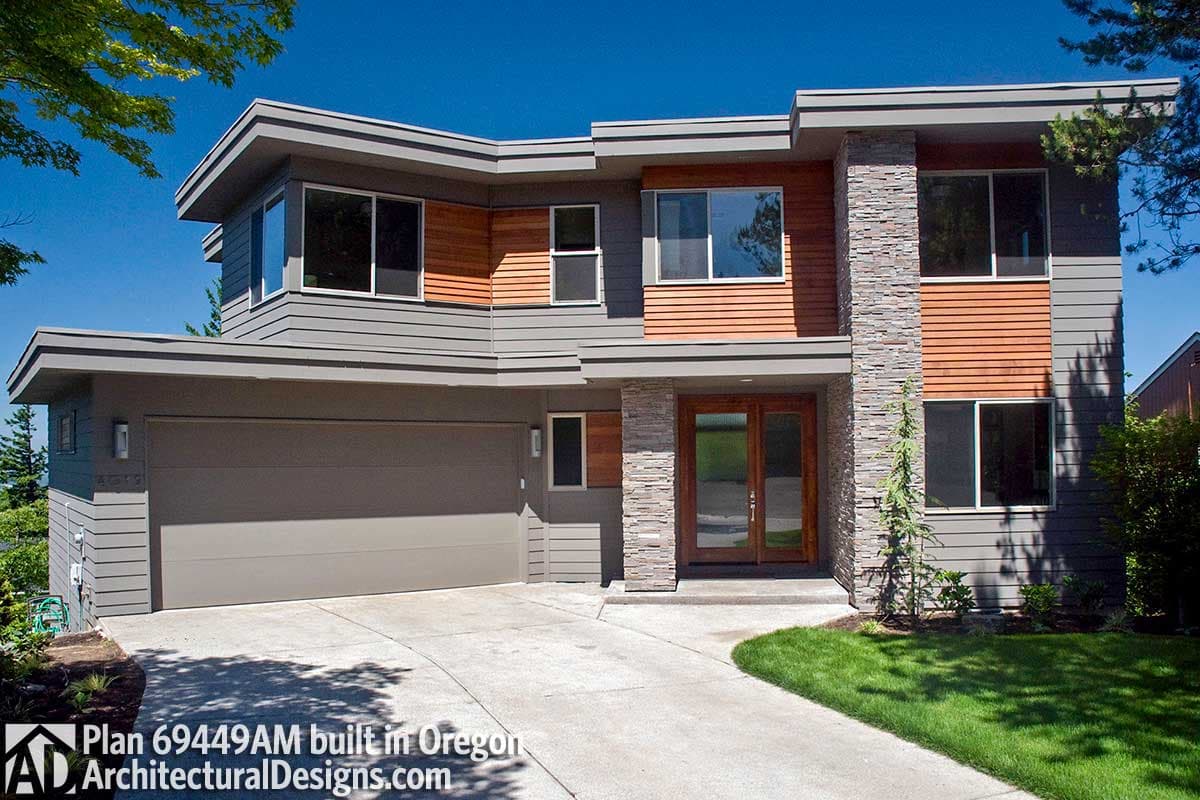 Modern house plan exterior with a two-car garage, horizontal siding, wood accents, stone pillar, and a double-door entry.