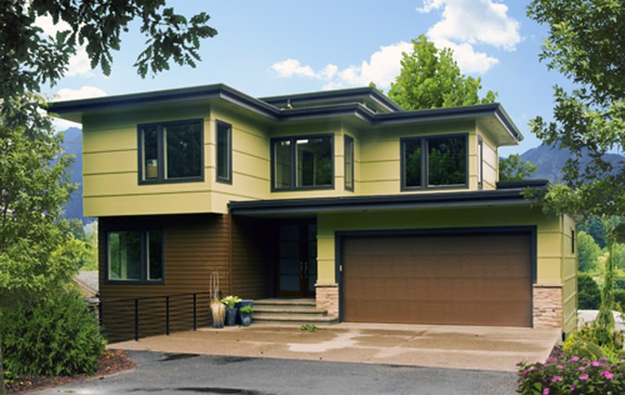 Modern two-story house plan exterior with a flat roof, horizontal siding, large windows, and an attached two-car garage.