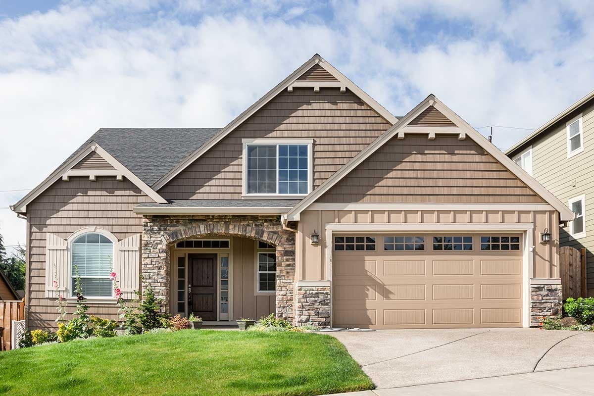 Craftsman house plan exterior with stone accents, arched entry, shingle siding, and a two-car garage.