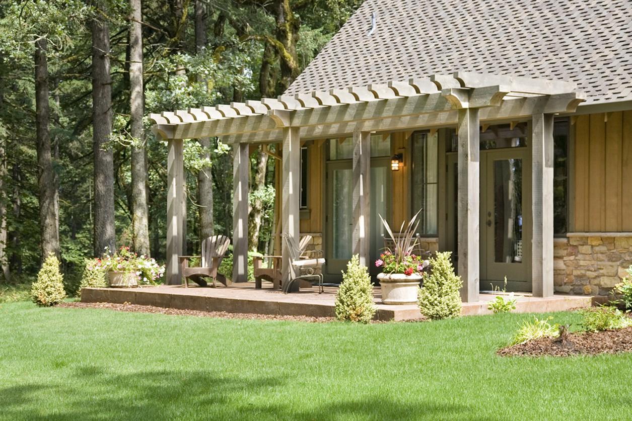 House plan exterior with a covered patio featuring a pergola, wood siding, and stone accents.