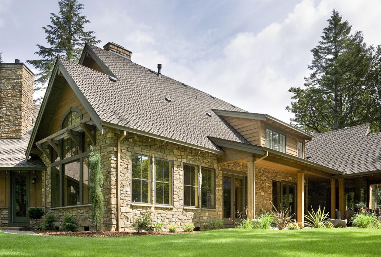 House plan exterior: Stone and wood two-story dwelling with prominent gables, stone chimney, and covered porch.