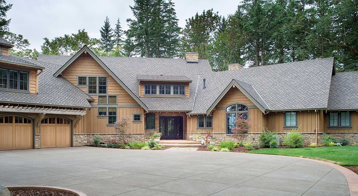 Craftsman style house plan exterior with a wide driveway, a three-car garage, stone accents, and multiple gables.